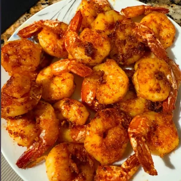 A white plate filled with golden-brown, seasoned shrimp from G Town Wings & Fish.