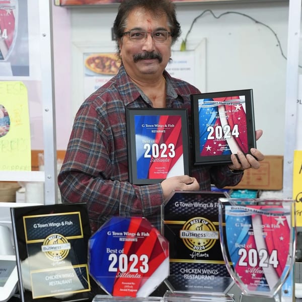 Owner of G Town Wings & Fish proudly displays "Best of Atlanta" awards for 2023 and 2024.