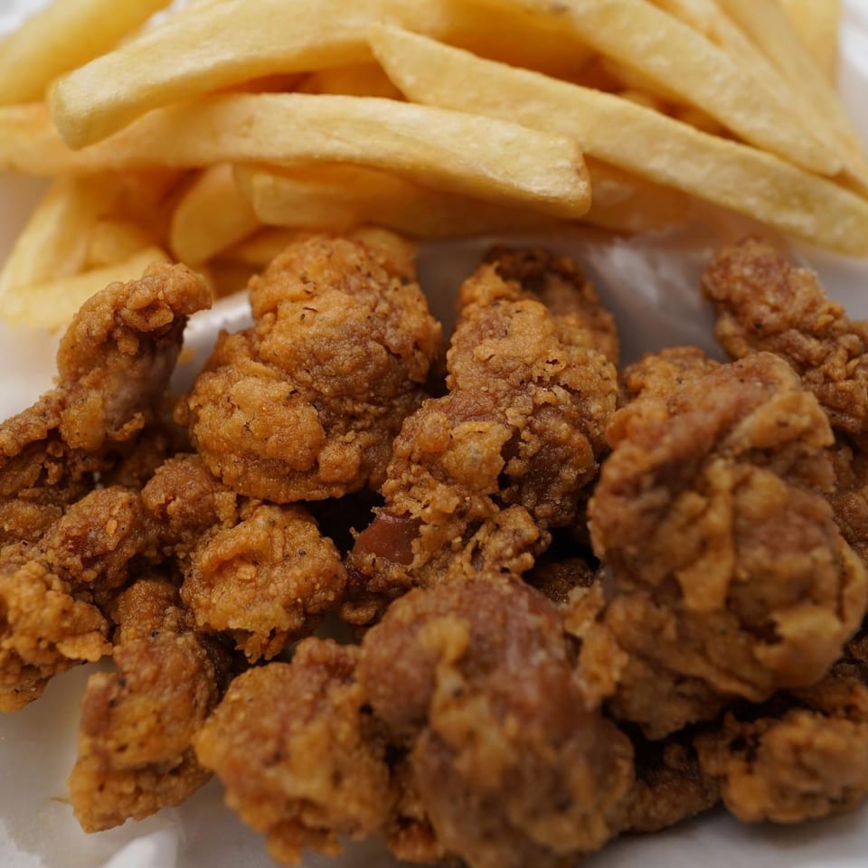 Close-up of crispy fried chicken pieces and golden french fries from G Town Wings & Fish.